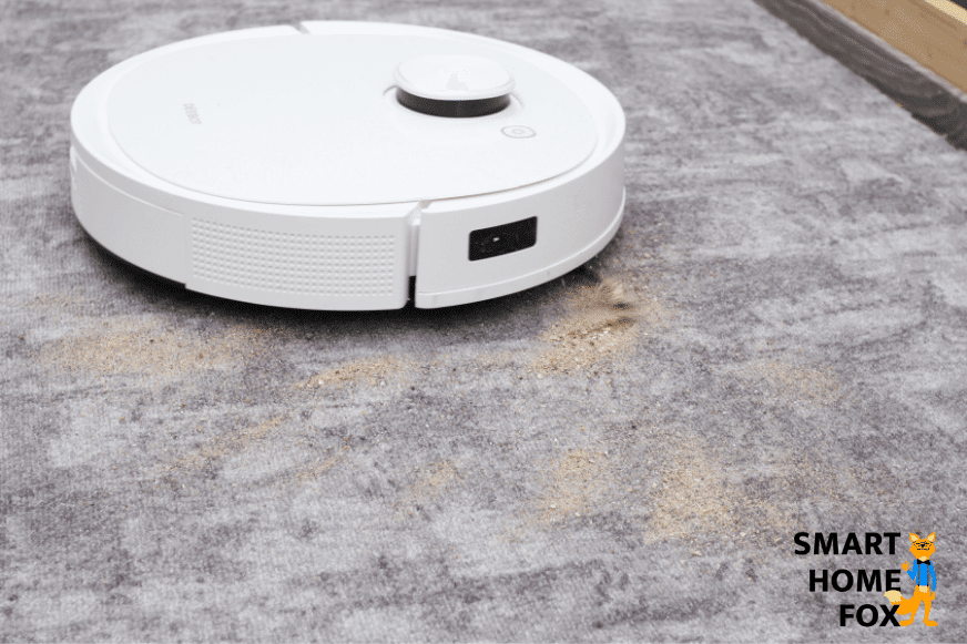 Ecovacs Deebot T9 reinigt Sand auf einem kurzflorigen Teppich